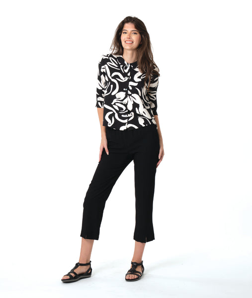 model in a slim black pant, worn with a black and white floral print button down blouse