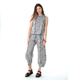 model in a barrel leg black and white striped pant, with a matching button down top with a twin button detail and no sleeves
