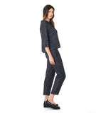 model in a grey and black pinstripe button down blouse with a matching slim leg pant with a contrasting tuxedo stripe