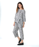 model in a barrel leg black and white striped pant, with a matching pullover top with a split at the bottom of either princess seam with a twin button detail and 3/4 sleeves
