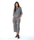 model in a black and white striped button down blouse with 3/4 sleeves, worn with a matching wide leg cargo pant with asymmetrical pockets