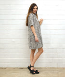 model in a black and white striped dress with short sleeves, knee length and an open, flat collar