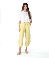 model in a yellow wide leg pant with a tapered ankle. worn with a short, boxy white button down blouse