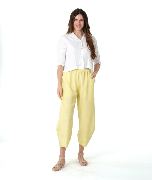 model in a yellow wide leg pant with a tapered ankle. worn with a short, boxy white button down blouse
