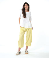 model in a wide leg yellow pant with a tapered ankle, worn with a white boxy pullover tee