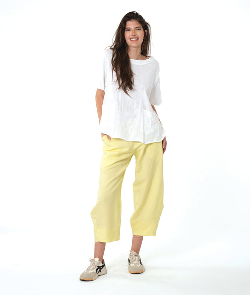 model in a wide leg yellow pant with a tapered ankle, worn with a white boxy pullover tee