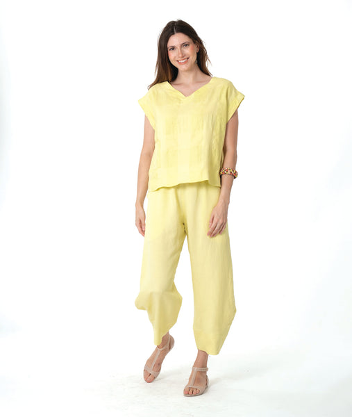 model in a wide leg yellow pant with a tapered ankle, worn with a matching yellow boxy pullover tee