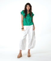 model in a wide leg white pant with a tapered ankle, worn with a green boxy pullover tee