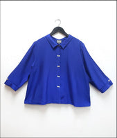 boxy electric blue button down top with a twin button detail along the front, back and sleeve cuffs