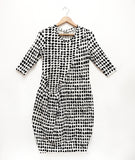 black and white dot print tunic with a curved hip pocket set into a diagonal seam across the body