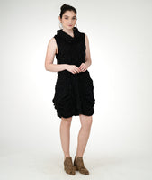 model in a black textured sleeveless tunic with an oversized cowl neck, princess seams and pockets set into the side seams