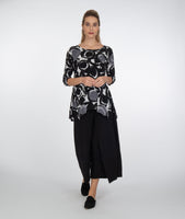 model in a black pant with a black and white circle print top