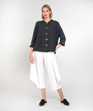 model in a white wide leg cropped pant with a charcoal button down boxy blouse with a 3/4 sleeves and a twin button detail