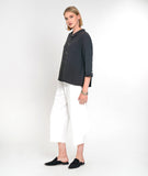 model in a white wide leg cropped pant with a charcoal button down boxy blouse with a 3/4 sleeves and a twin button detail