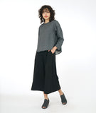 model in a boxy grey top with a wide leg black cropped pant with pockets