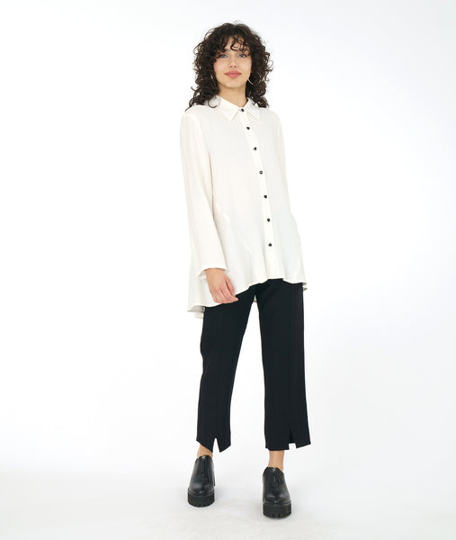 model in a white button down blouse worn with a slim black pant