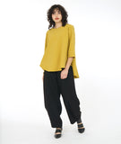 model in a wide leg black pant worn with a gold top with a full flowing body and 3/4 sleeves