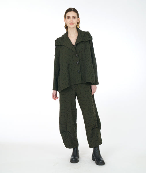model in a distressed green wide leg pant with a pleat at either calf, with a matching boxy jacket