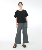 model in a wide leg grey pant worn with a boxy short sleeve black top