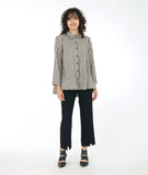 model in a slim black pant with a split at either ankle front center, worn with a taupe and black stripe button down blouse