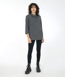 model in black leggings with a 3/4 sleeve black and white leaf print tunic with a cowl neck