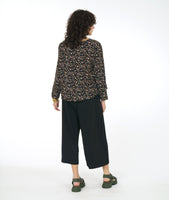 model in a wide leg black pant with a black terrazzo print top. top is boxy and has long sleeves