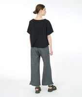 model in a wide leg grey pant worn with a boxy short sleeve black top