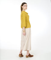 model in a wide leg ivory pant with a gold cowl neck top