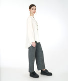 model in a white button down blouse with a mandarin style collar and a low draped back, worn with a wide leg grey pant