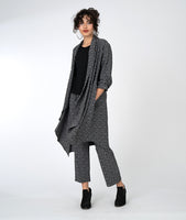 model in a black and white leaf print pant with a matching duster sweater and a black tee