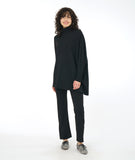 model in a slim black pant and asymmetrical black top with a mock turtle neck and one full cocoon sleeve