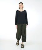 model in a wide leg distressed olive pant with a pucker at each calf, and a matching boxy black top with long sleeves
