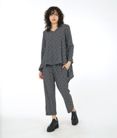 model in a black and white leaf print straight leg pant, worn with a matching tunic with long sleeves, a v-neck and a low double point drape in the back 