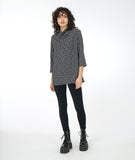 model in black leggings with a 3/4 sleeve black and white leaf print tunic with a cowl neck
