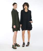 two models in matching green and black distressed tunics with long sleeves, a cowl neck, and princess seams with a pleating detail at the hips
