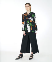 model in a wide leg black pant with a multi color paint swatch print blouse with a mandarin styler standing collar