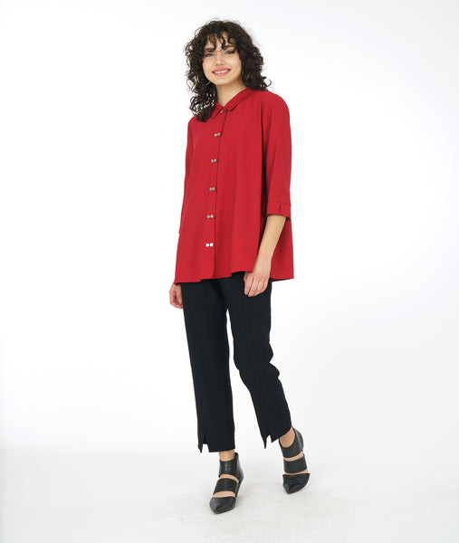 model in a slim black pant with a long button down red blouse with 3/4 sleeves and a twin button detail