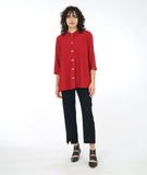 model in a slim black pant with a long button down red blouse with 3/4 sleeves and a twin button detail