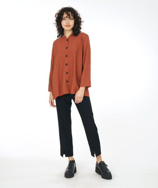 model in a slim black pant with a rust color button down blouse