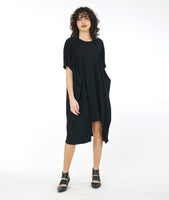 model in a black tunic dress with a convertiable strap extending from the waist, worn around the neck in a number of different styles