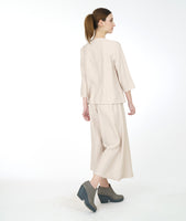 model in a pearl color cowl neck top with a wide leg matching pant