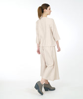 model in a pearl color cowl neck top with a wide leg matching pant