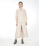 model in a pearl color cowl neck top with a wide leg matching pant