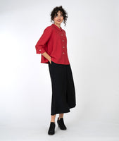 model in a wide leg black pant with a red button down blouse with a twin button detail and a 3/4 sleeve