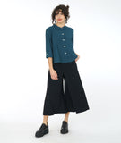 model in a wide leg black pant with a teal button down blouse with a twin button detail and a 3/4 sleeve