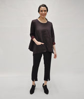 model in a black pant with a split at the ankle, worn with a black and red dot print top with a full body and a single pocket 