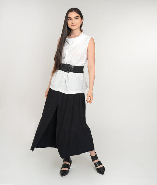 model in a wide leg black pant with an overlay flap, with a white tank