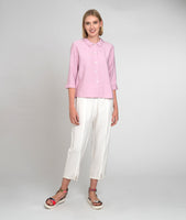 model in a white cropped pant with a pink button up blouse