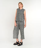 model in a black and white striped sleeveless button up blouse with a matching pant