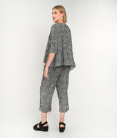 model in a black and white striped pant with a matching top with a flowy body and single square hip pocket